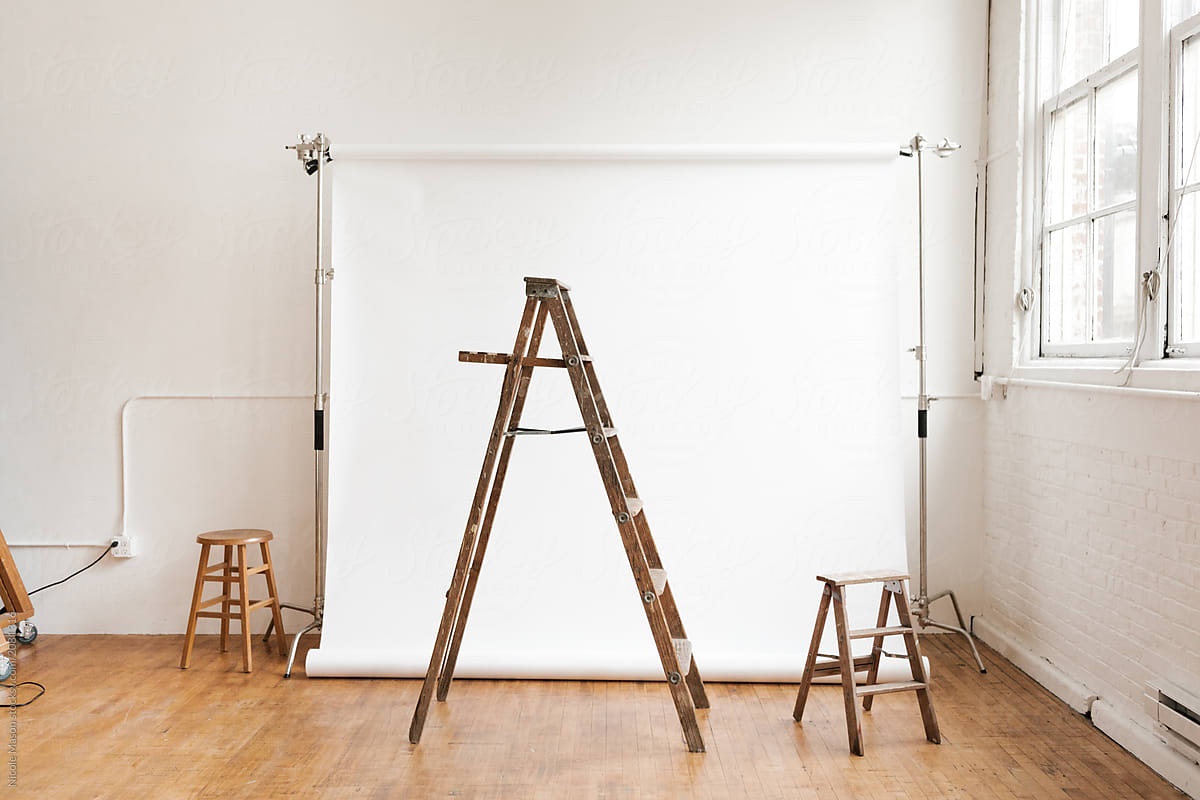 ladders in front of white photo studio backdrop in industrial studio space