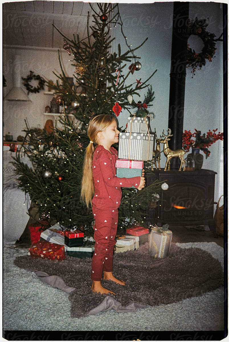 Child with stack of Christmas boxes, ugc