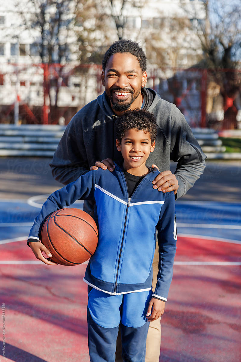 Portrait of happy father and son ready to play basketball