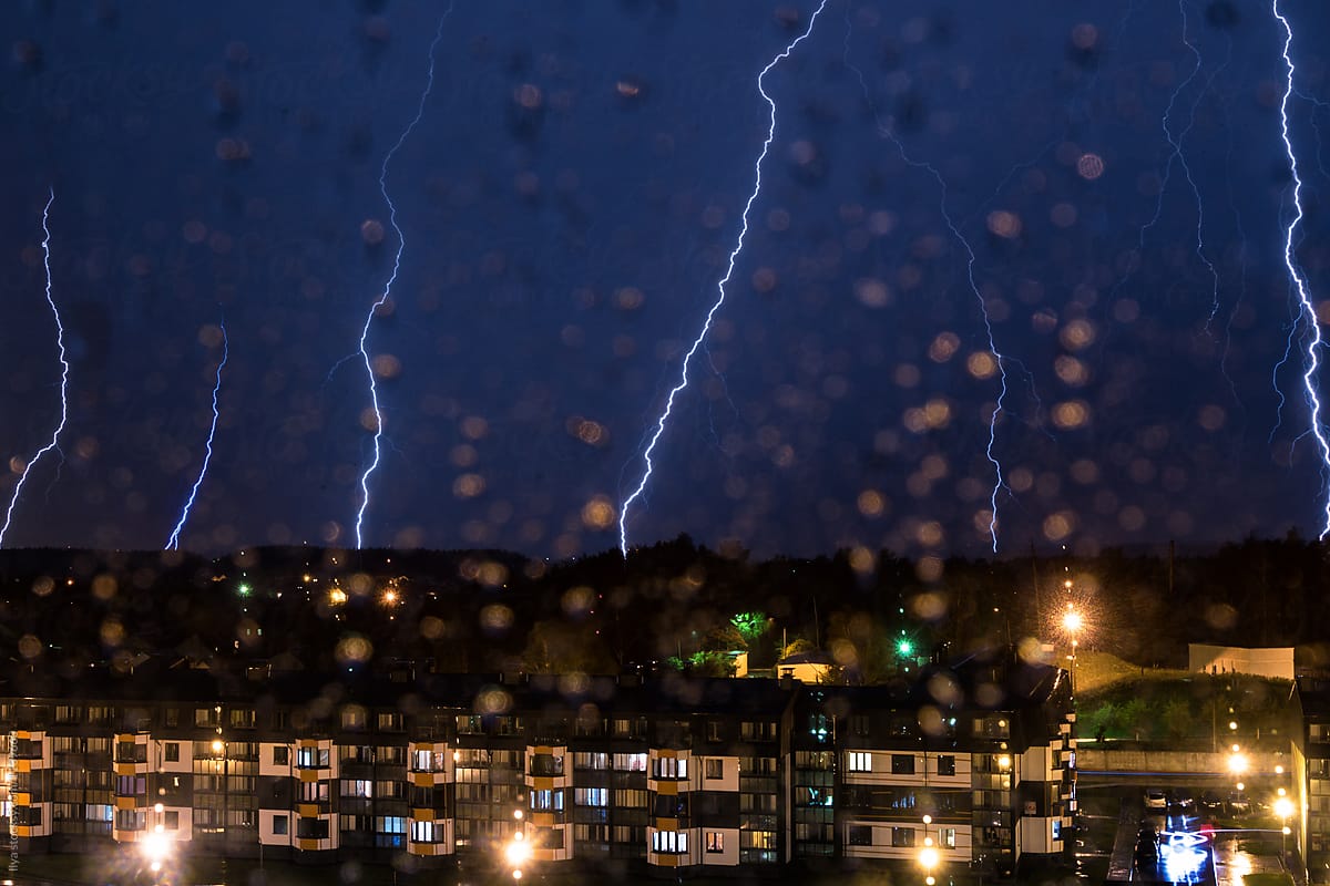 Thunderstorm over city in the night with many lightning bolts