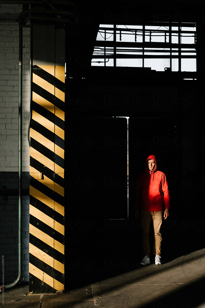 Man standing in shadow in industrial building