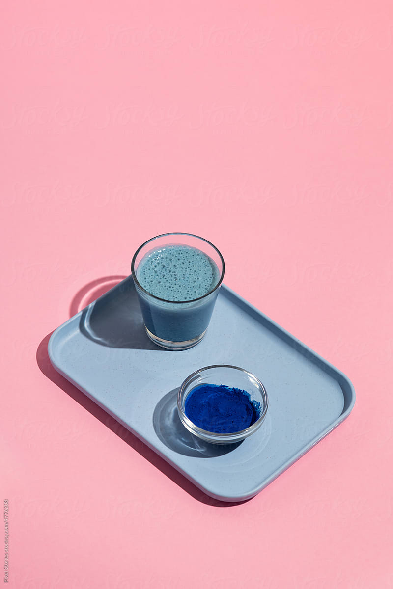 Blue spirulina healthy superfood drink with glass, bottle and powder