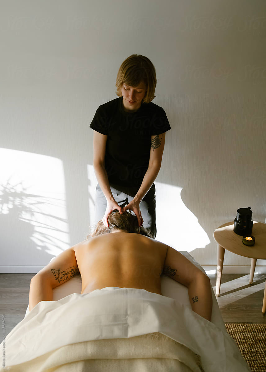 female massage therapist working with female client