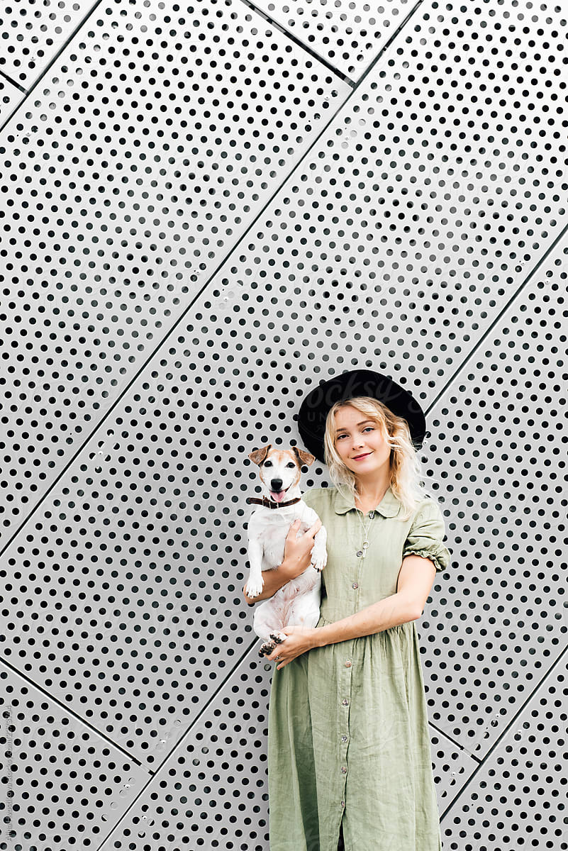 Pretty woman carrying adorable dog outdoors