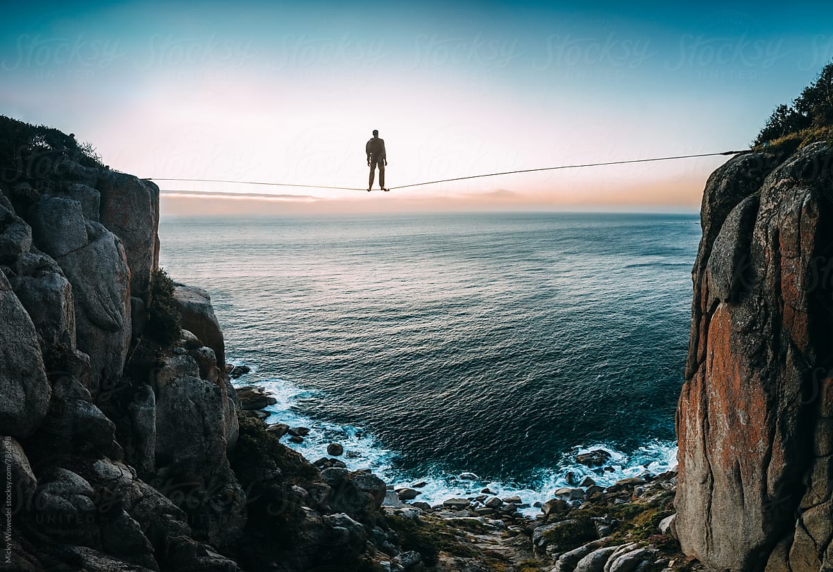 A man standing on a tightrope over the sea