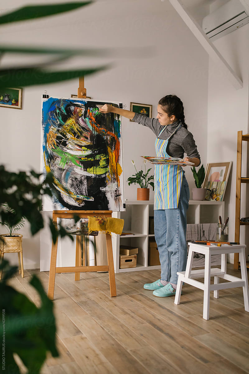 Young artist painting on canvas at home