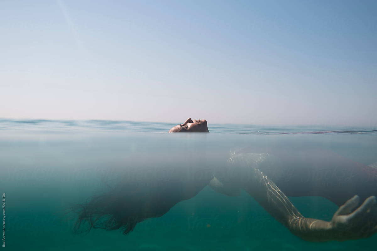 Woman floating in the sea resembling a dream