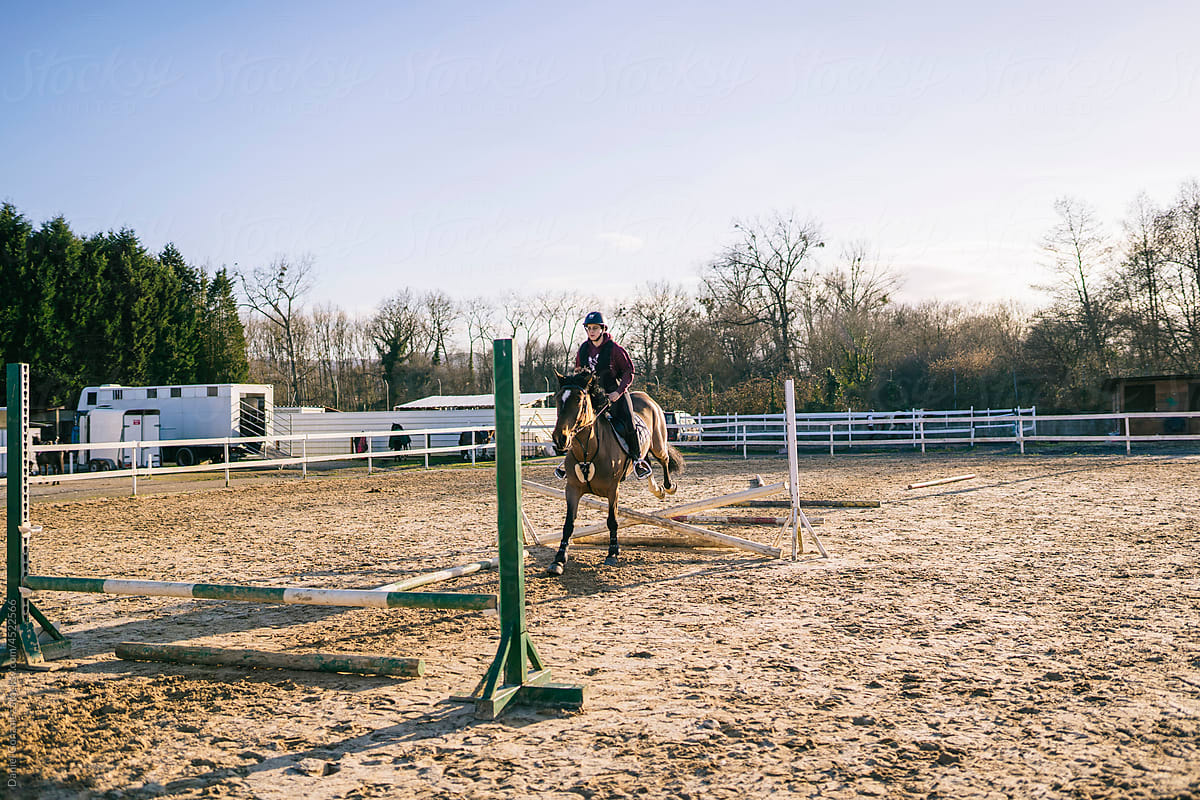 Female jockey riding horse to barrier
