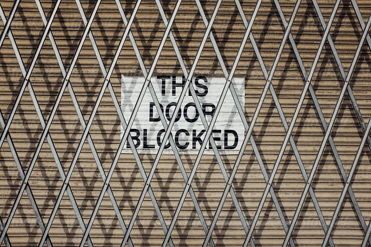 Metal fence across warehouse door with sign reading \