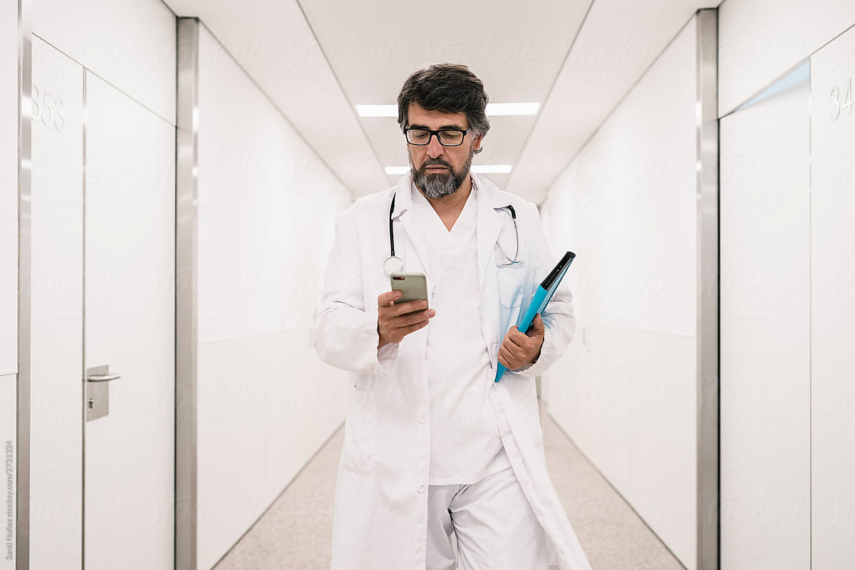 Doctor checking his phone while working in a hospital
