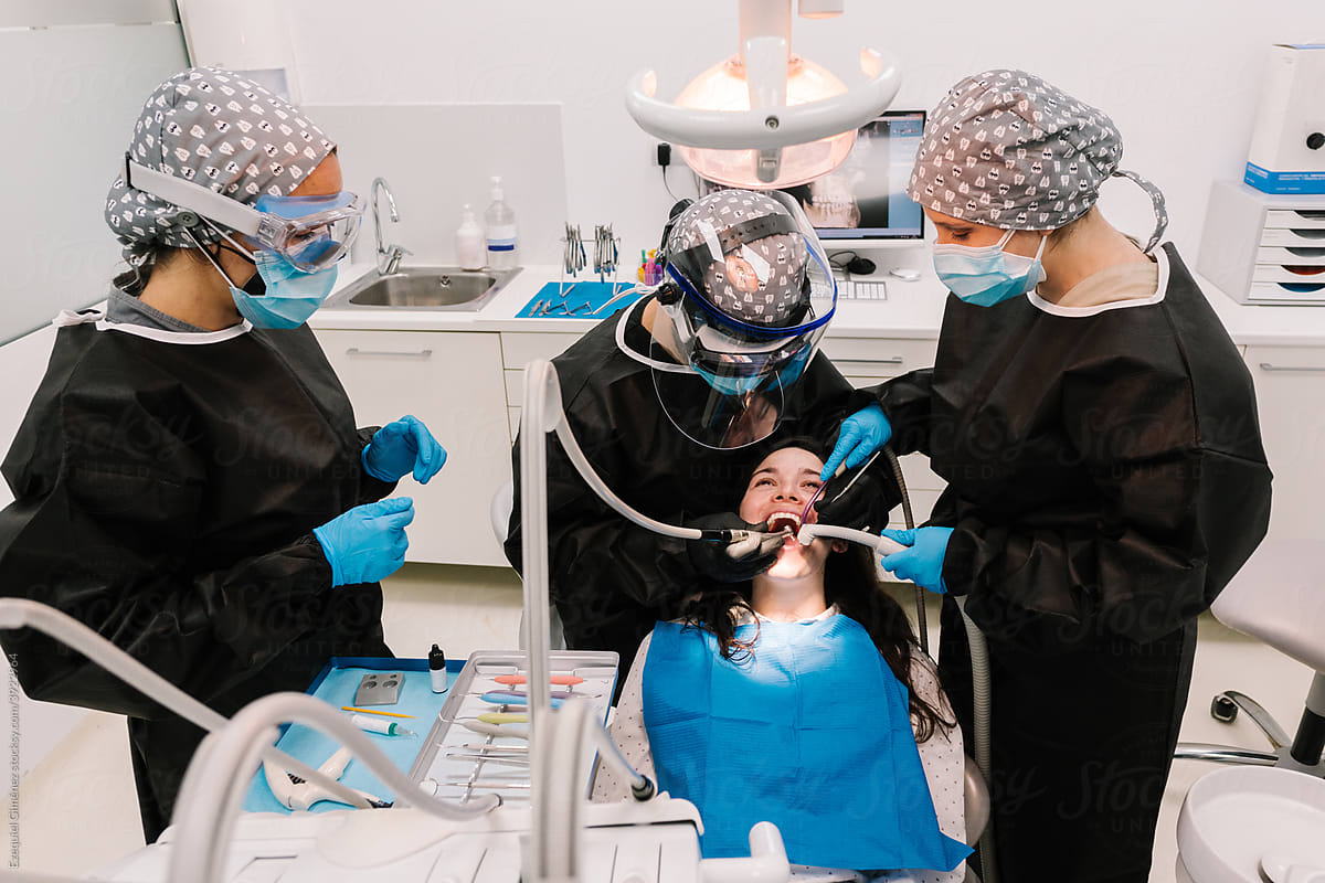 Dentist and assistants treating a patient in the clinic