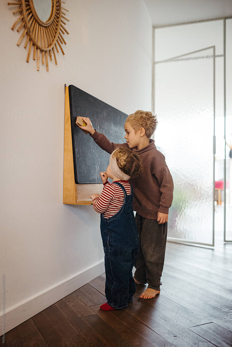 Toddlers writing on chalkboard