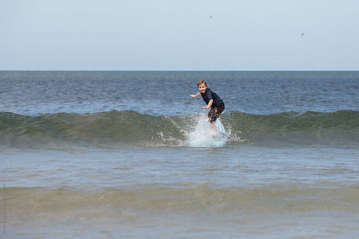 Boy surfing making a splash in the waves in Costa Rica