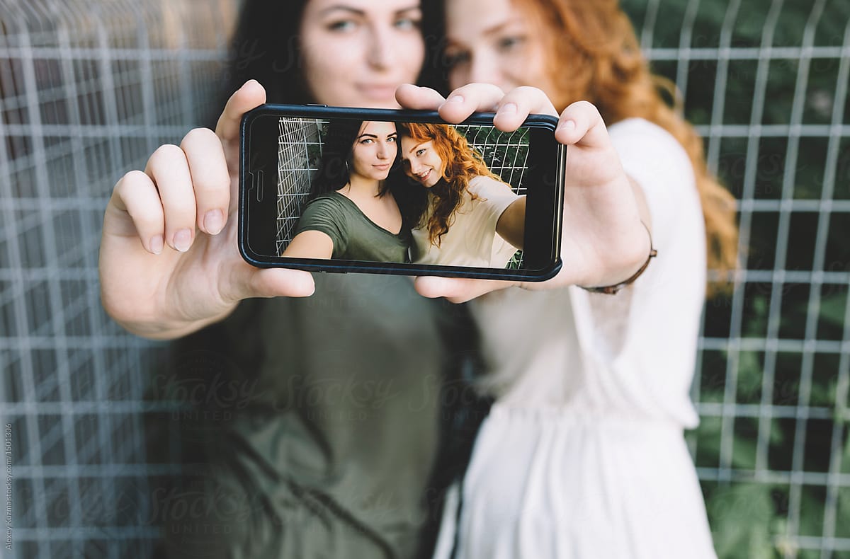 A Lesbian Couple Taking A Selfie Outdoors By Stocksy Contributor Alexey Kuzma Stocksy