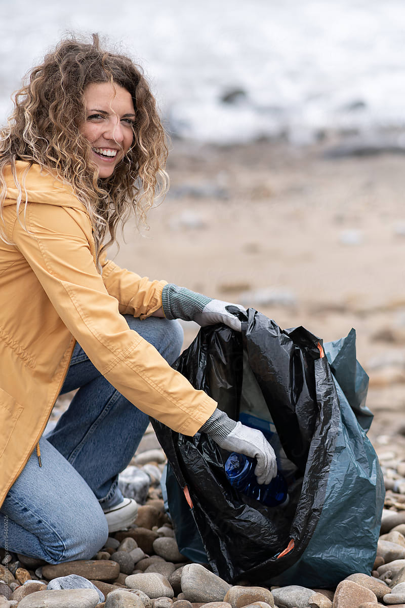 Woman cleaning up beach.