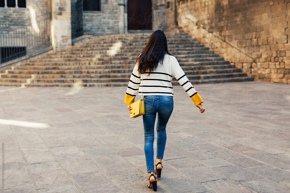 Back View Of A Stylish Woman Walking On The Street. by Stocksy Contributor  BONNINSTUDIO  - Stocksy