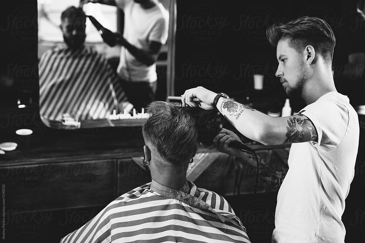 Barber blowing blond client\'s hair