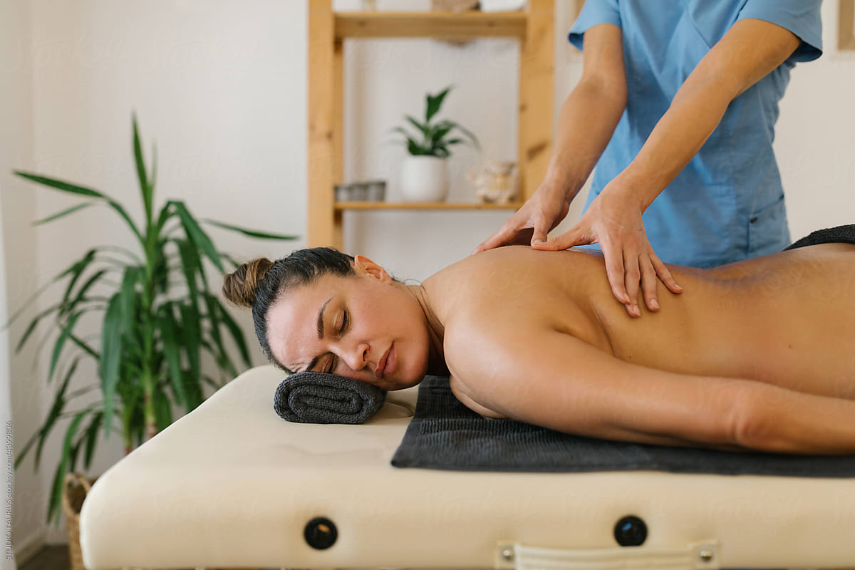 Middle aged woman having oil massage in massage room