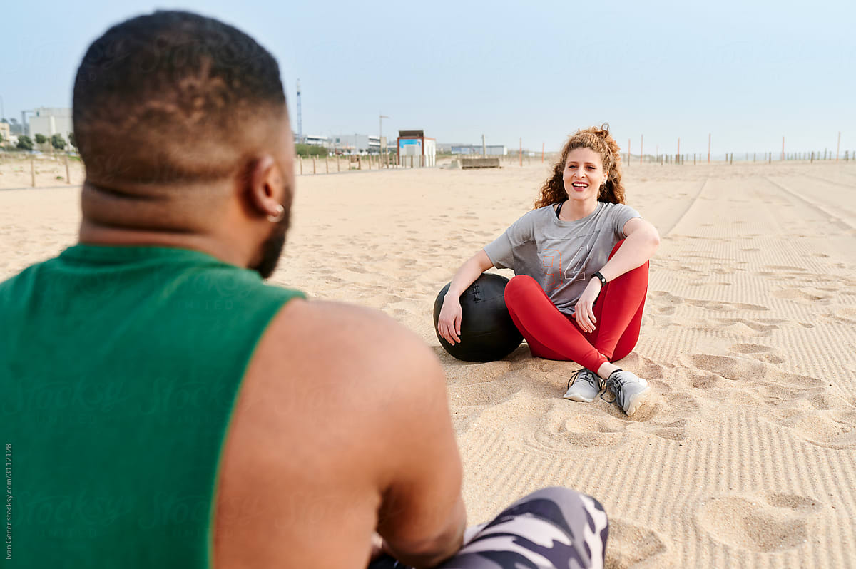 Woman talking with a friend after a beach workout