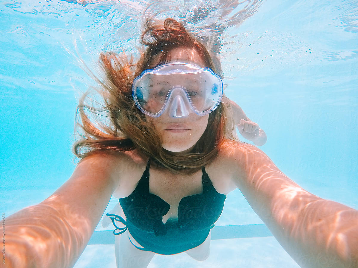 Woman taking self portrait underwater.
