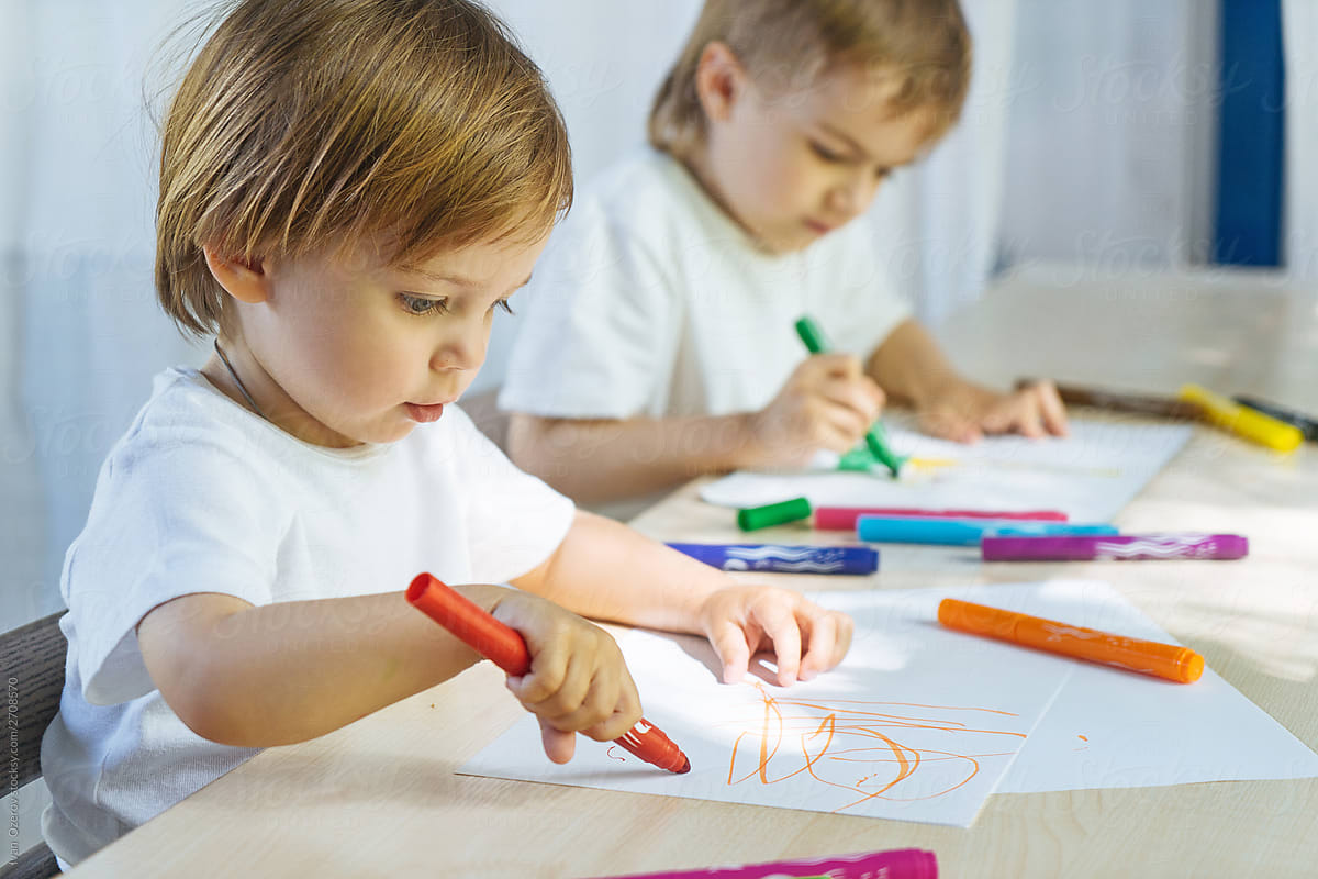 Captivated children drawing together at table