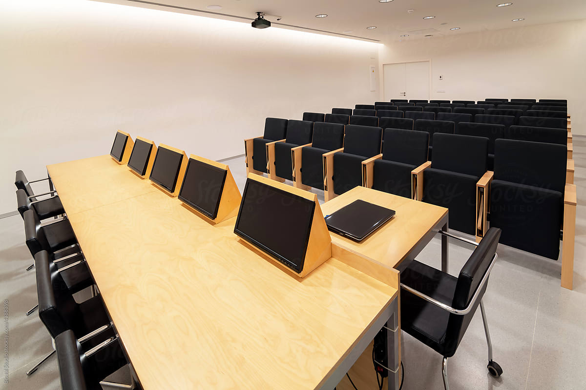 Modern displays on table in conference room with chairs