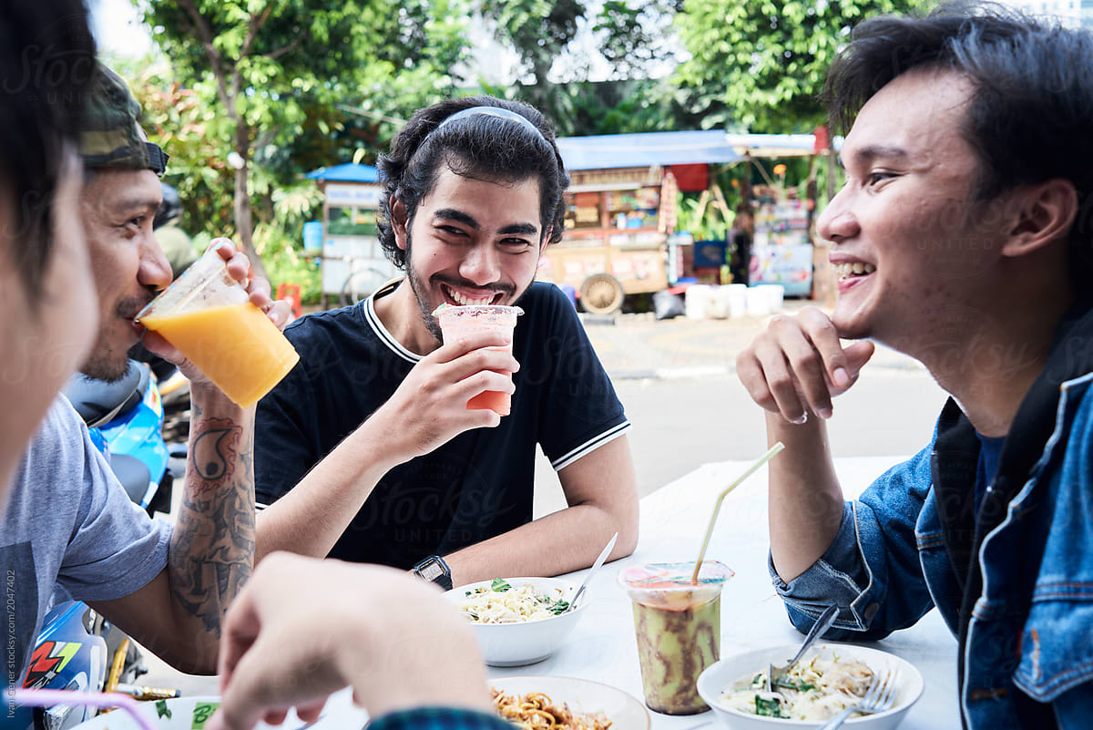 Male friends eating asian street food