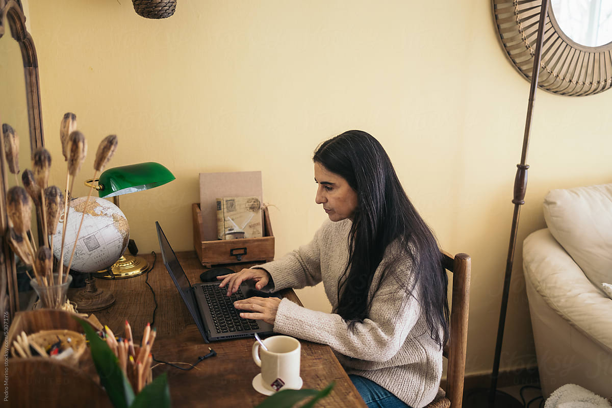 Mature woman using laptop in her cozy home office