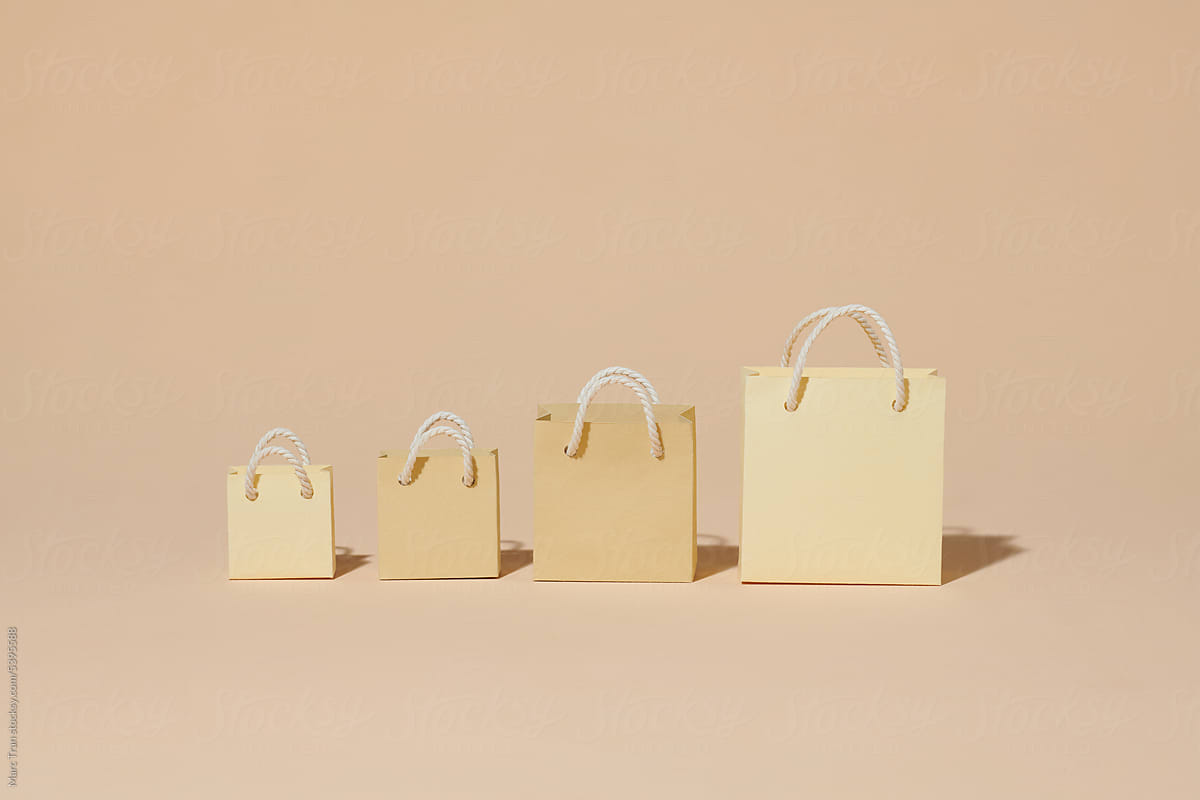 Set with kraft paper shopping bags on beige background