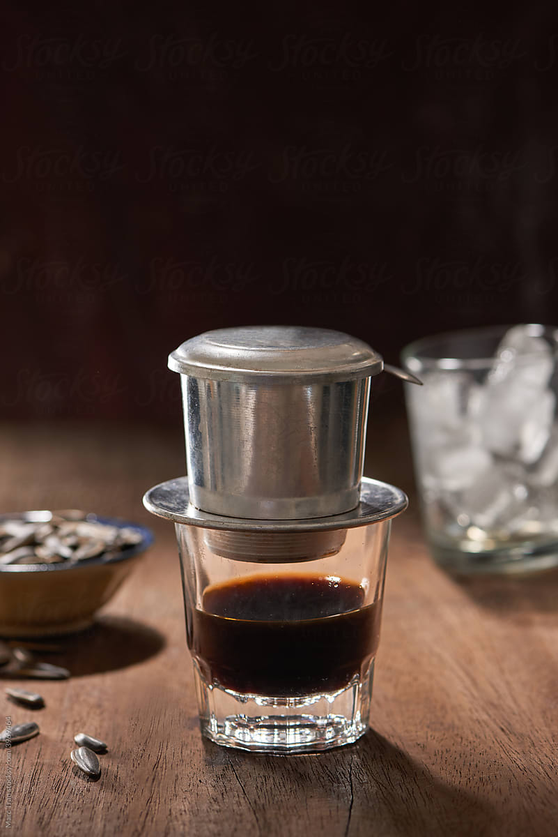 Vietnamese coffee with drip filter on wood background