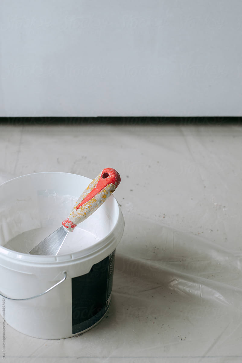 Spatula in a bucket with decorative plaster