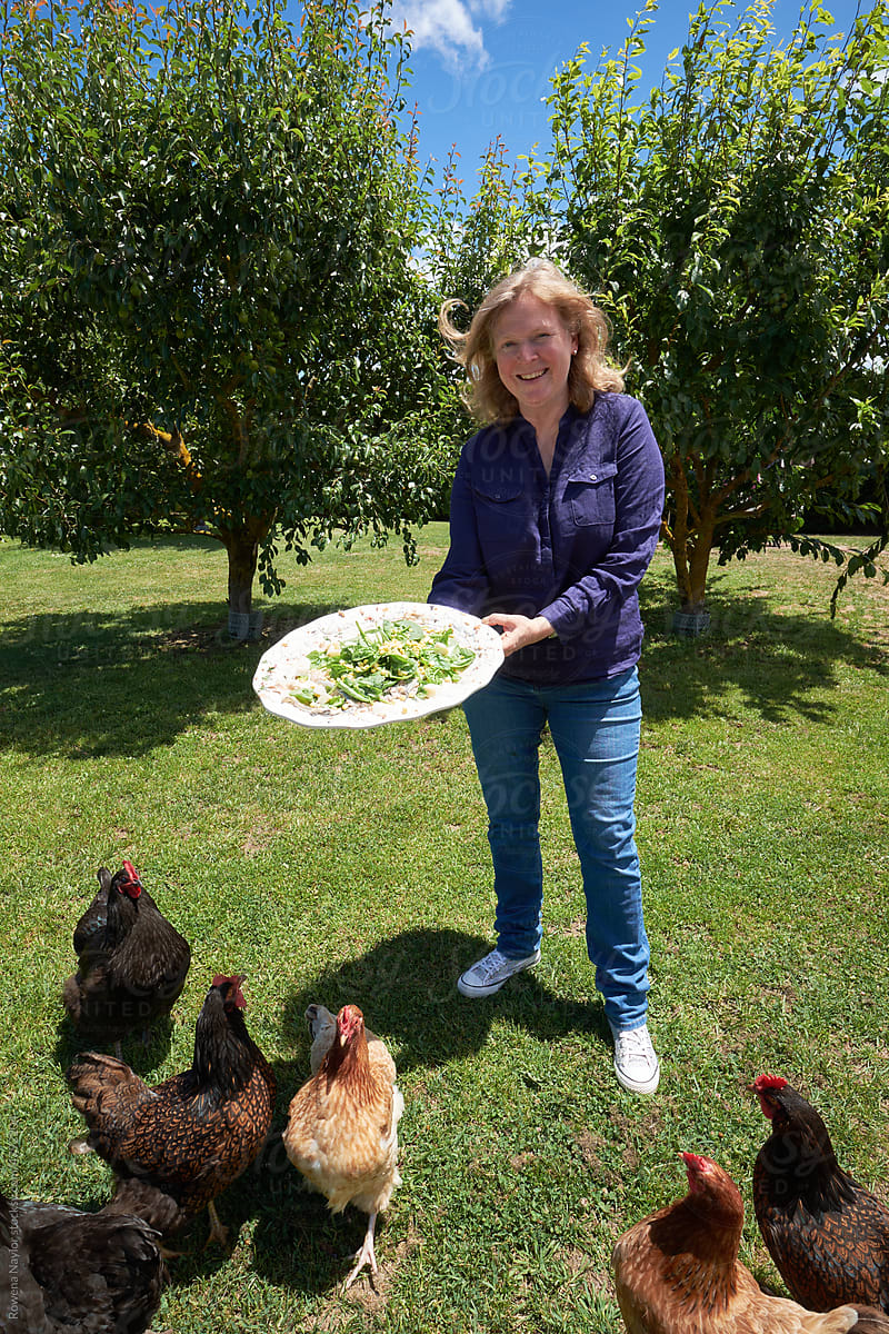 Woman feeding pet chickens