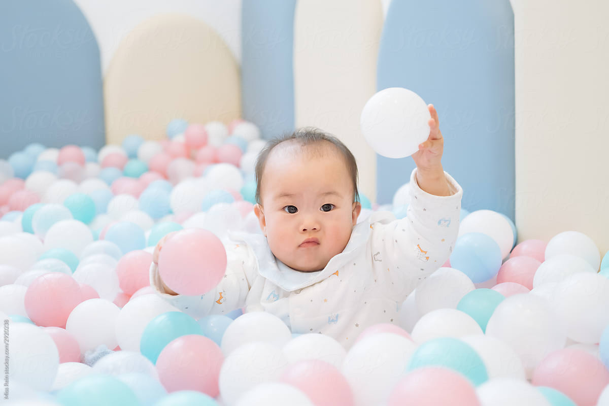 A baby playing with balls
