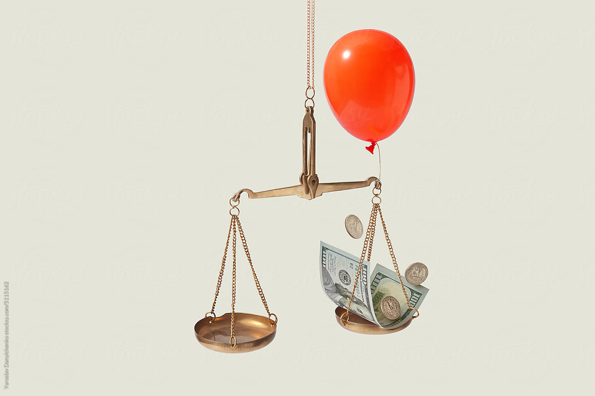 Dollar on vintage scales with red balloon.