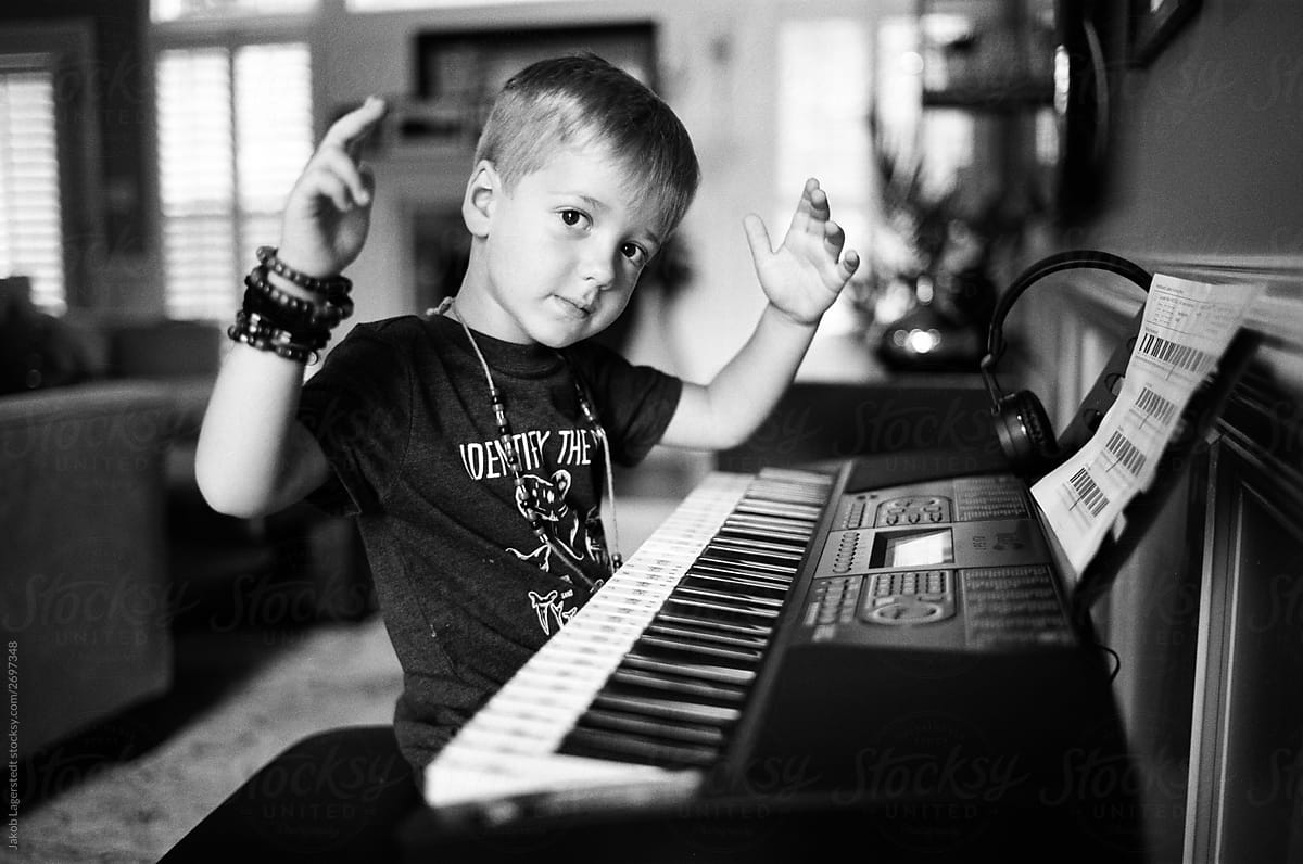 Cute young boy playing a keyboard piano