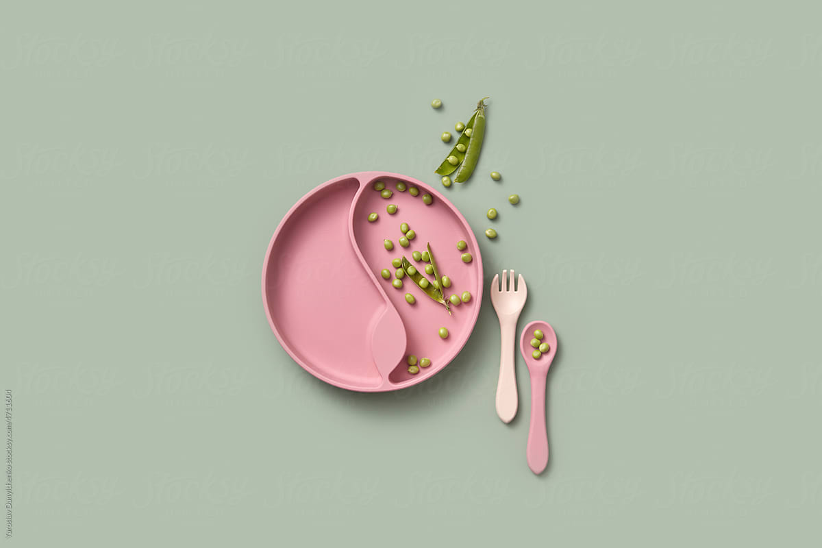 Kid plate with open pea pods, spoon and fork