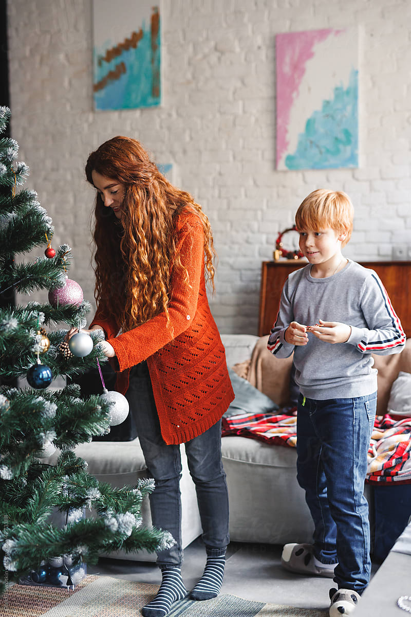 Christmas time family dress up artificial fir tree living room