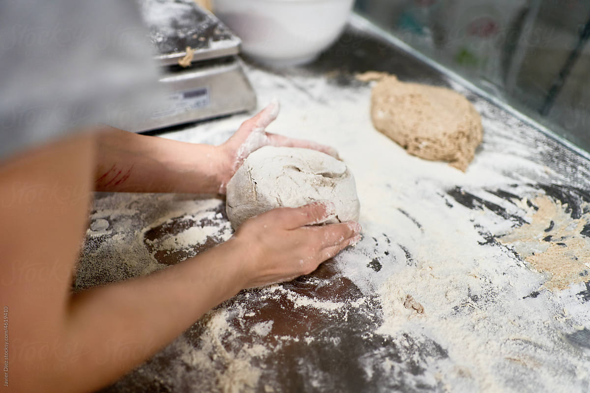 Crop woman making loafs from dough