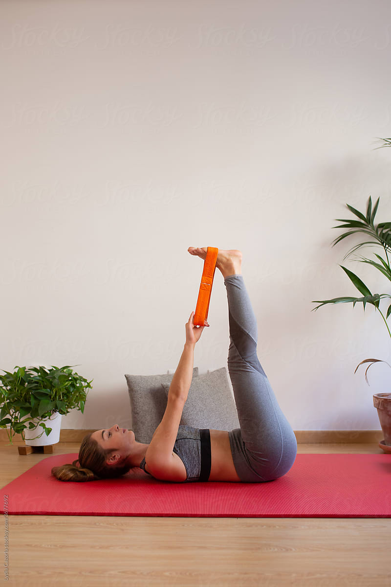 Young woman practicing yoga online is her apartment