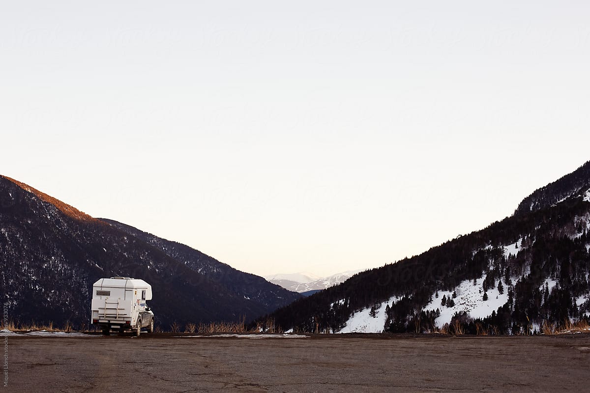 Scenic view of parked van in a mountain road at winter.