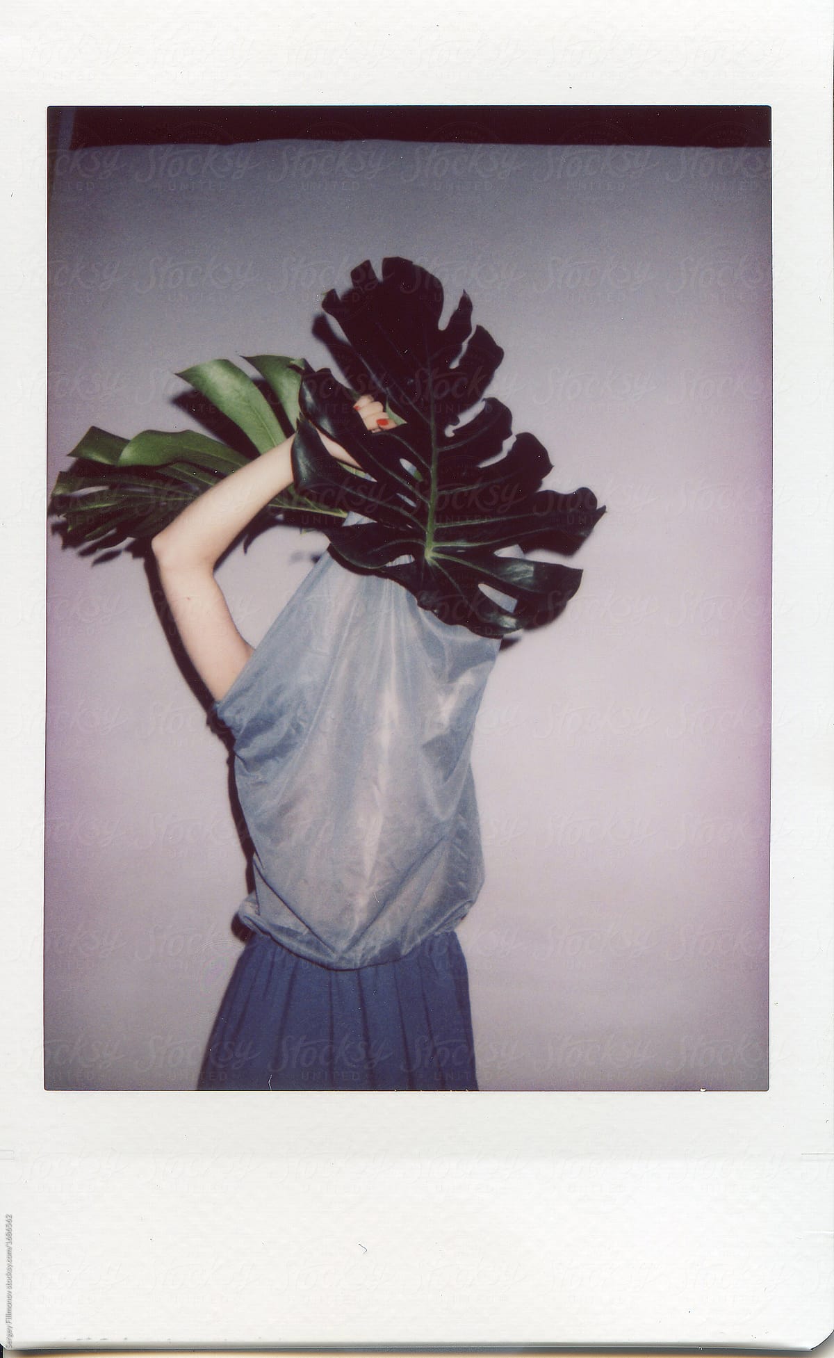 Anonymous model with plant on instant photo