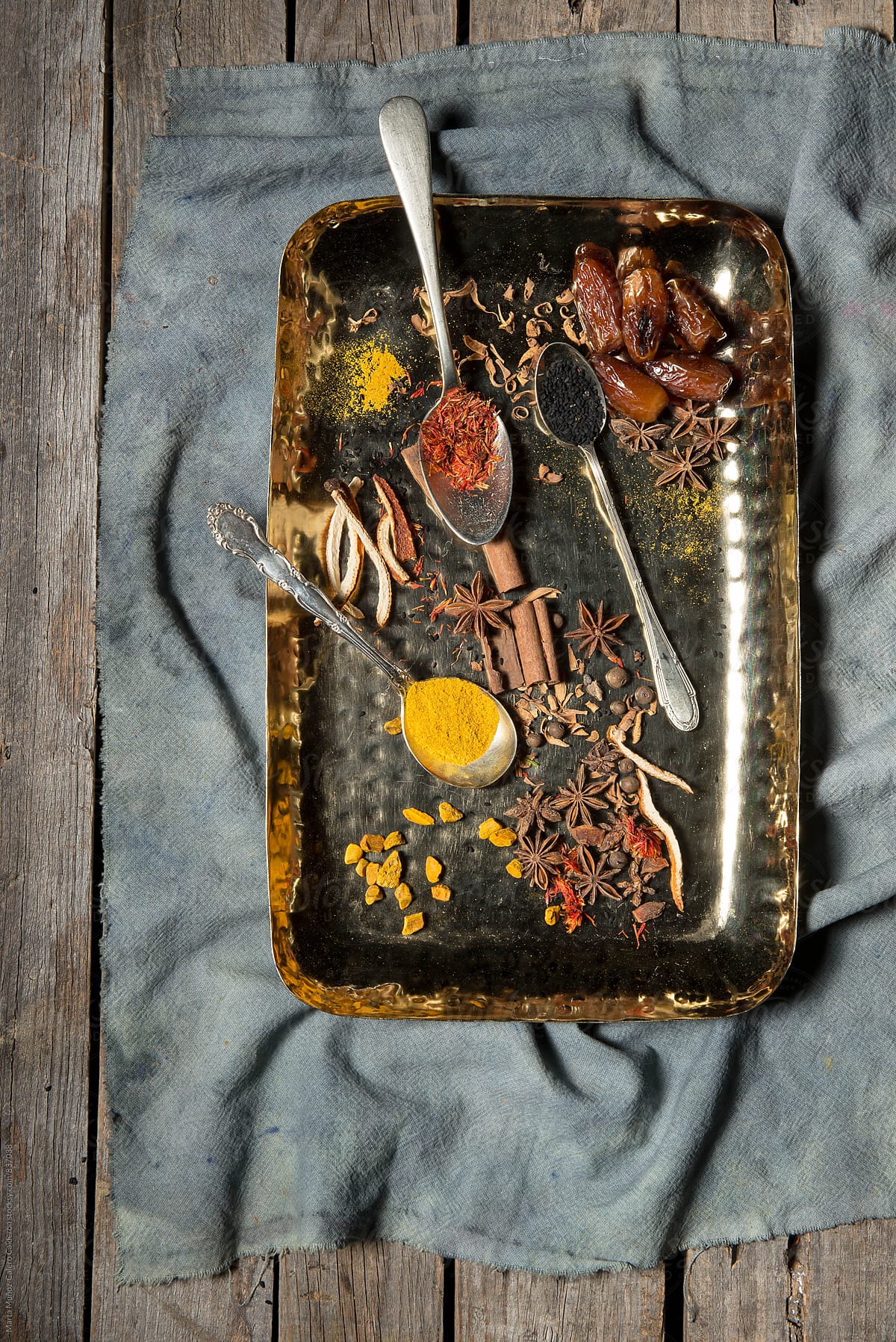 Several species on metal tray on a vintage piece of fabric with a  worn wood surface