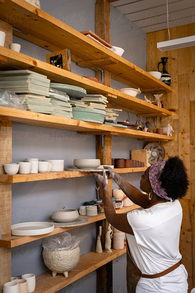 Woman reaching out to put her work to shelf