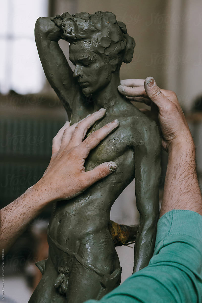 Hands of sculptor mold clay statue