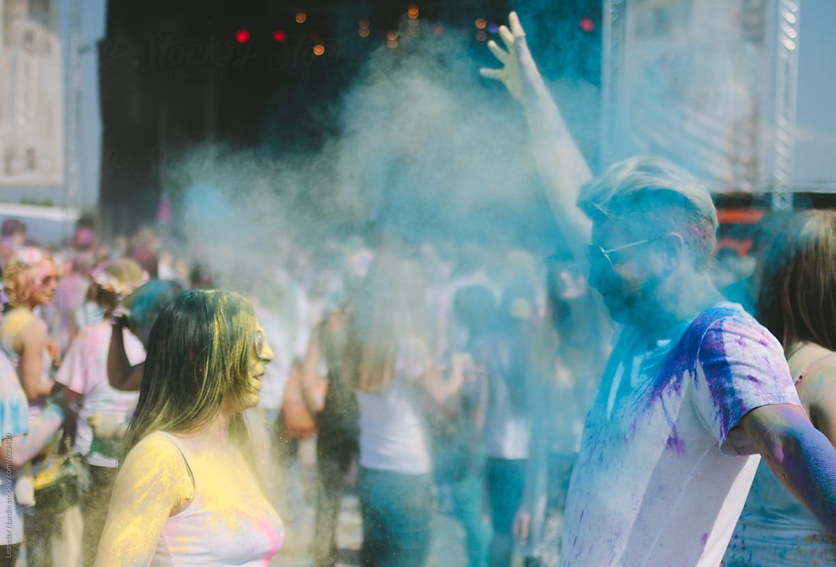 young colorfully painted couple having fun at an outdoor music festival