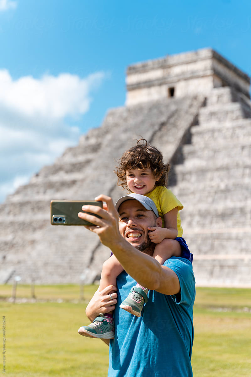 Father and daughter taking a selfie photo in Chichen Itzá, Mexico