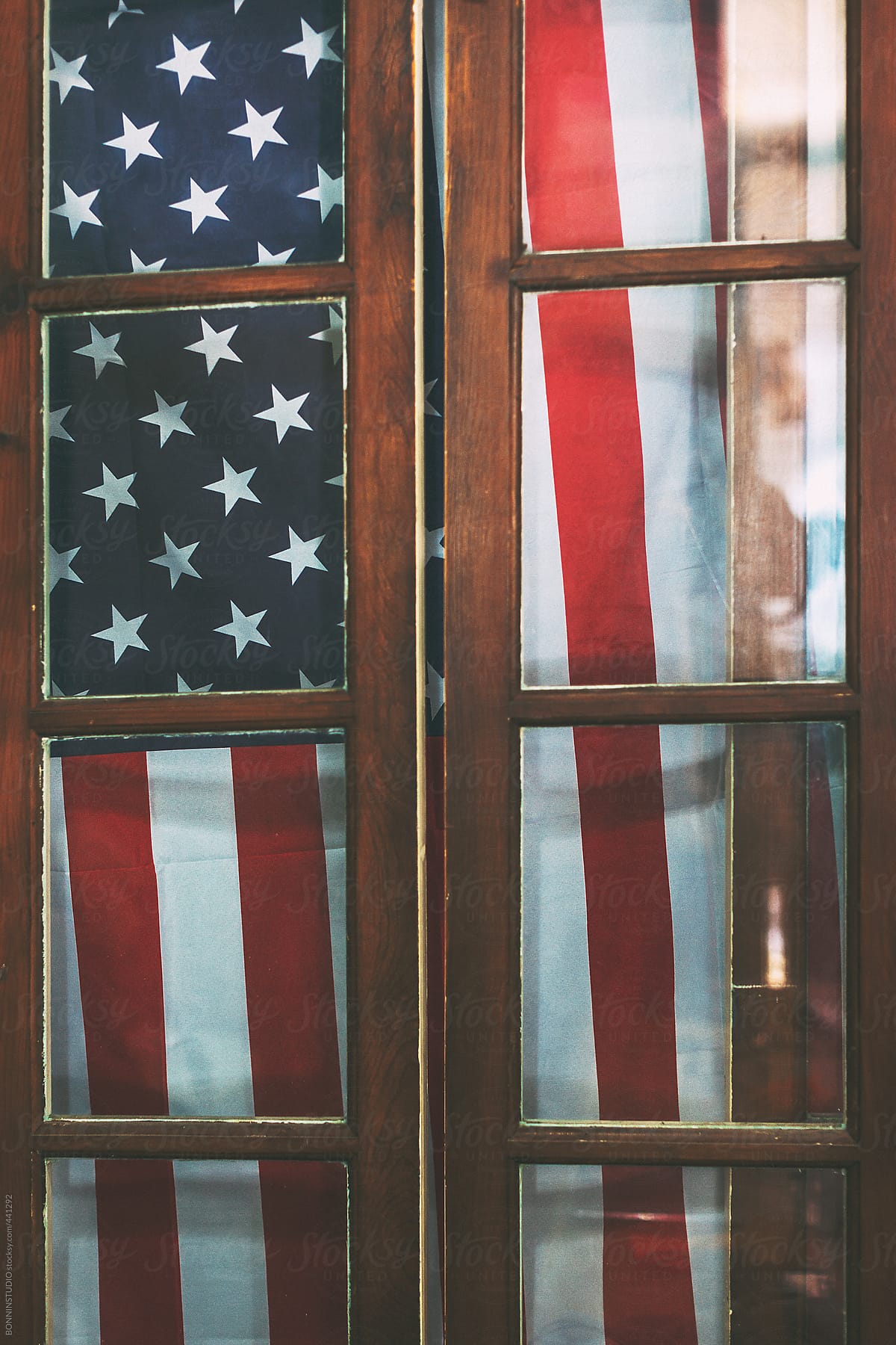 American flag behing a wood window.