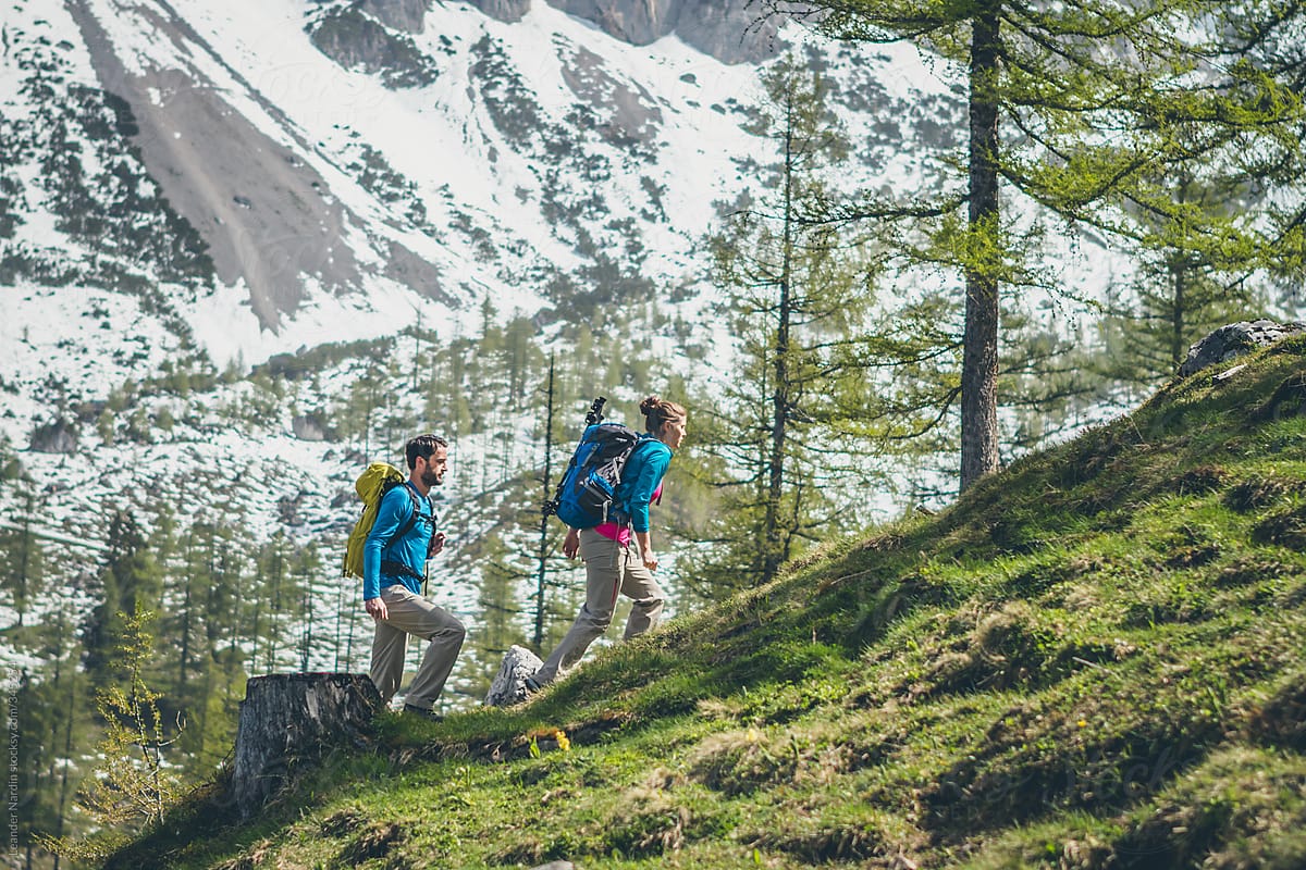couple hiking through the forest in the austrian alps
