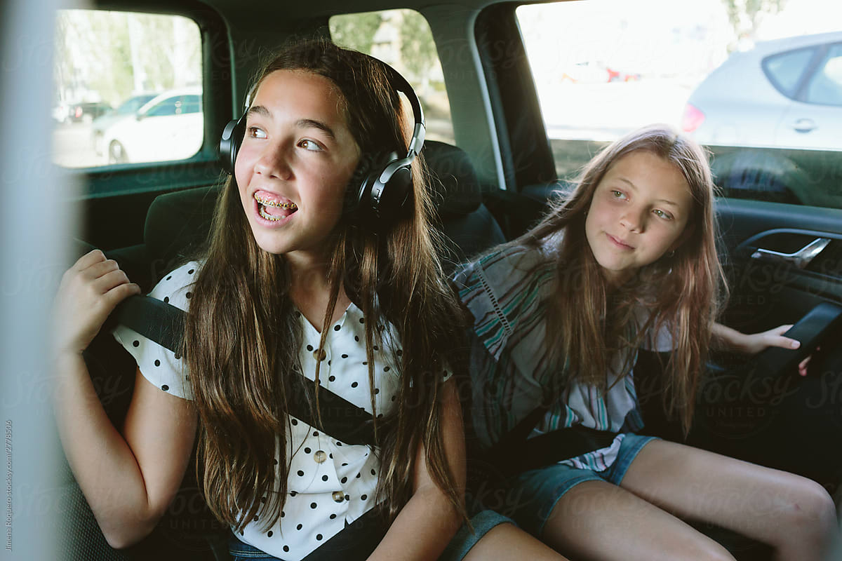 Two Teenage Girls In The Back Seat Of A Car Looking Outside Cheerful By 