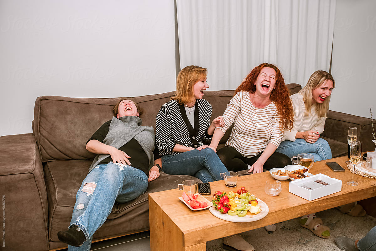 Joyful Laughter. Women in Fits of Laughter on a Sofa.